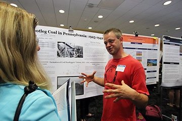 Student presents his project at a summer research symposium