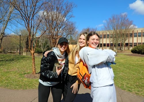 Friends enjoy the warmth of a spring morning on campus